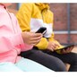 childhood, technology and people concept - close up of children with smartphone and tablet computer sitting on wooden street bench outdoors
