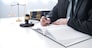 Legal counsel presents to the client a signed contract with gavel and legal law. justice and lawyer concept