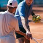 Tennis instructor with young boy in tennis training lesson
