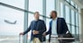 Travel for business, team at airport and men, catch flight for work trip with conference or training seminar with accountant. Walk, talk and diversity with finance convention and partnership