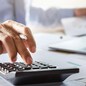 accountant working on desk using calculator for calculate finance report in office