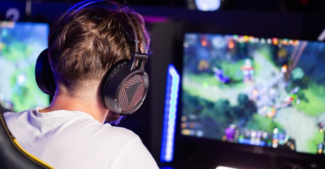 E-sport tournament Gamer in headset plays video game on PC Computer club, real-time strategy RTS multiplayer online battle competition. Skill. Gaming earphones.