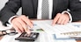 Businessman working with using a calculator to calculate the numbers. Finance accounting concept
