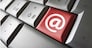 Web and Internet contact us concept with at icon and symbol on a red laptop computer key for blog and on line business.