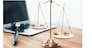 Symbolizing justice and legal authority, golden balanced scale and gavel on desk with laptop in law office background, reflecting concept of equality and fair judgment by lawyer and judge. equility