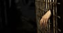 Human hand through a prison cell in the conclusion