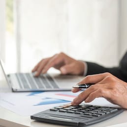Asian businessman hands calculating number, graph, chart audit planning accountancy on business report. Asian professional Business man hands using calculator counting tax financial bill. Tax audit Finacial concept.