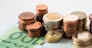 business and money saving concept - close up of euro coins and paper money banknotes