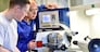 young apprentices in technical vocational training are taught by older trainers on a cnc lathes machine