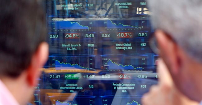 Due uomini guardano i prezzi delle azioni di Lehman Brothers Holdings Inc. I mercati globali sono crollati lunedì dopo che la banca d’investimento Lehman Brothers ha presentato istanza di protezione fallimentare, la rivale Merrill Lynch ha accettato di essere rilevata e la Federal Reserve ha lanciato un salvagente al malconcio settore finanziario. (REUTERS/Gary Hershorn)