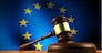European Union law, legislation and parliament concept with a 3d rendering of a gavel on a wooden desktop and the EU flag on background.