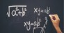 The hand that writes the formula with white chalk on the blackboard