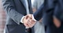 closeup of handshake of business partners on the background of business team