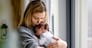 Loving mother hugs her little baby at home