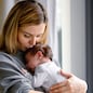Loving mother hugs her little baby at home