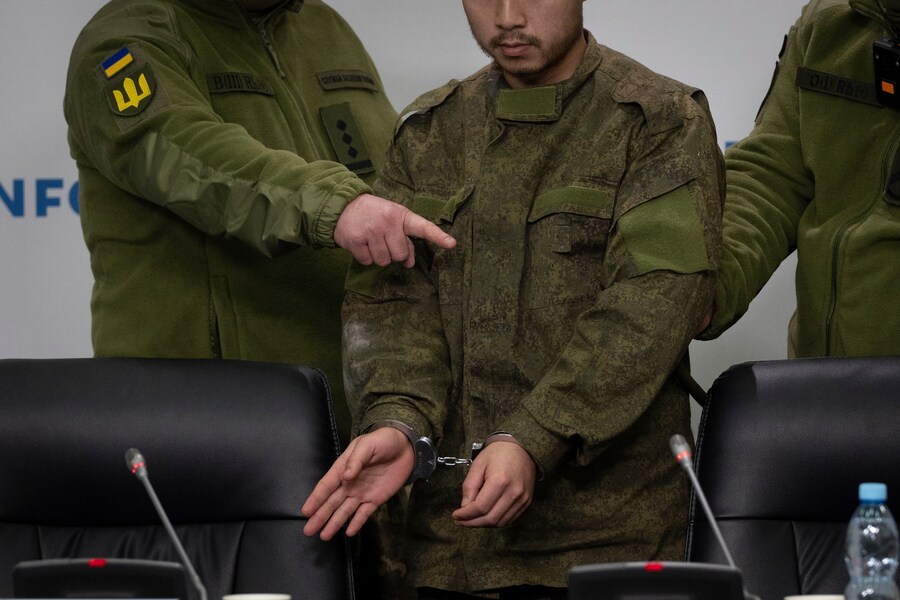 Agenti di sicurezza ucraini scortano un cittadino cinese ammanettato (al centro), catturato dalle forze ucraine mentre combatteva dalla parte russa, a una conferenza stampa a Kiev, Ucraina, lunedì 14 aprile 2025. (AP Photo/Efrem Lukatsky) (APN)
