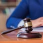 Handsome judge with gavel sitting in courtroom