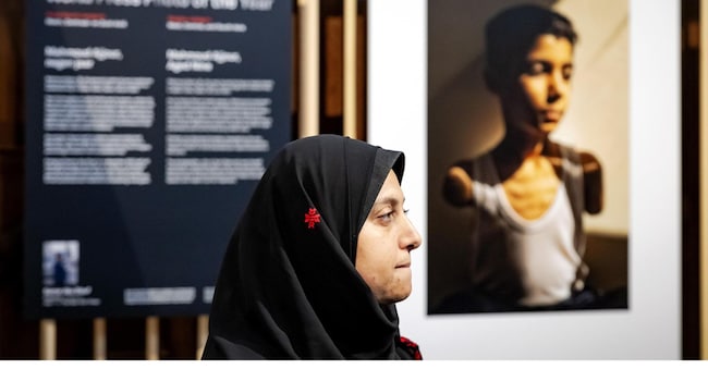 epa12036416 Palestinian photographer Samar Abu Elouf poses before her World Press Photo of the Year winning photograph, during the announcement of the World Press Photo winners at the Nieuwe Kerk in Amstedam, Netherlands, 17 April 2025. Presented every year, the World Press Photo is one of the most prestigious awards for photojournalists  EPA/ROBIN VAN LONKHUIJSEN