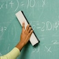 Person removing formulas from the blackboard
