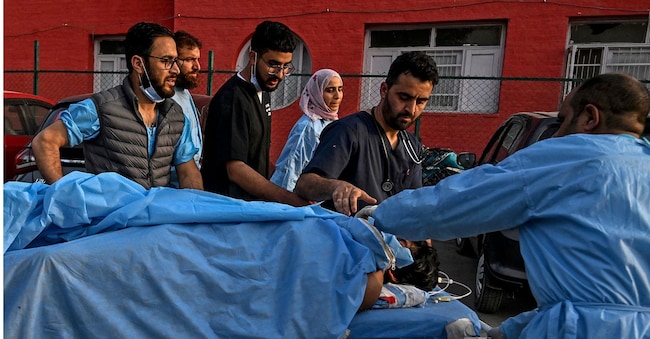 I paramedici trasportano un turista ferito in un ospedale di Anantnag, a sud di Srinagar, il 22 aprile 2025, dopo un attacco di uomini armati nel Kashmir (Tauseef Mustafa/ Afp)