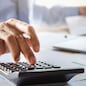accountant working on desk using calculator for calculate finance report in office