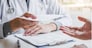 Doctor or physician writing diagnosis and giving a medical prescription to male Patient