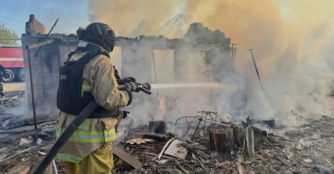 Pompiere ucraino intento a spegnere un incendio causato da un raid russo nella regione del Donetsk