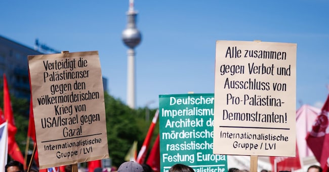  I partecipanti tengono i cartelli “Difendete i palestinesi contro la guerra genocida di USA/Israele contro Gaza!” (L), “Tutti insieme contro il divieto e l’esclusione delle manifestazioni a favore della Palestina!” (R) durante una manifestazione in occasione della Giornata Internazionale dei Lavoratori a Berlino, Germania, il 1° maggio 2025.  EPA/CLEMENS BILAN