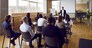 Team of people having class with business trainer. Group of male and female employees sitting at desks in modern office and listening to lecture by experienced teacher sharing knowledge and guidance