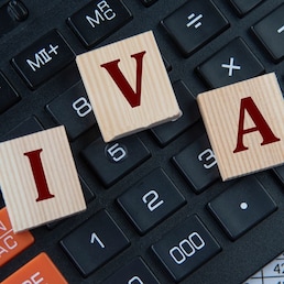 IVA (Individual Voluntary Arrangement) - acronym on wooden cubes on the background of a calculator. Business concept