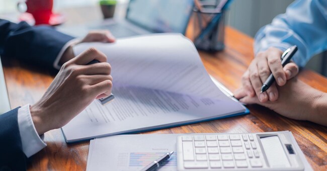 Businesswoman reviewed mortgage document and contract with their client, ensuring loan and credit details were clear, while discussing estate insurance and other finance aspects. finance, credit, pay.