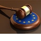 European Union laws, legal system and parliament concept with a 3d render of a gavel on a wooden desktop and the EU flag.