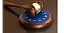 European Union laws, legal system and parliament concept with a 3d render of a gavel on a wooden desktop and the EU flag.