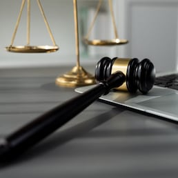 Symbolizing justice and legal authority, golden balanced scale and gavel on desk with laptop in law office background, reflecting concept of equality and fair judgment by lawyer and judge. equility