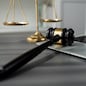 Symbolizing justice and legal authority, golden balanced scale and gavel on desk with laptop in law office background, reflecting concept of equality and fair judgment by lawyer and judge. equility