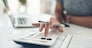 Finance planning, budget or savings manager calculating expenses, taxes or company profits with laptop, paperwork or calculator. Closeup hands of female financial leader checking office staff payroll.