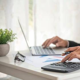 Asian businessman hands calculating number, graph, chart audit planning accountancy on business report. Asian professional Business man hands using calculator counting tax financial bill. Tax audit Finacial concept.