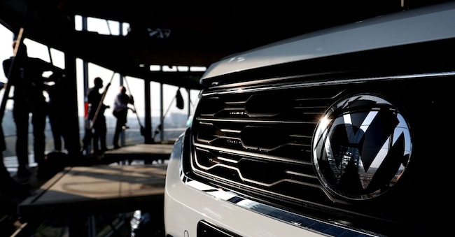 La torre del deposito auto della casa automobilistica tedesca Volkswagen si riflette nel logo VW presso la sede della società a Wolfsburg (Foto di Ronny HARTMANN / AFP) 