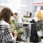workers in an industrial garment factory sew clothes on sewing machine