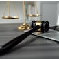 Symbolizing justice and legal authority, golden balanced scale and gavel on desk with laptop in law office background, reflecting concept of equality and fair judgment by lawyer and judge. equility