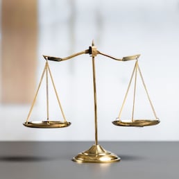 Shiny golden balanced scale in court library background as concept justice and fairness legal symbol. Scale balance for righteous and equality judgment by lawyer and attorney. equility
