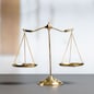 Shiny golden balanced scale in court library background as concept justice and fairness legal symbol. Scale balance for righteous and equality judgment by lawyer and attorney. equility