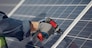 Engineer in a white helmet. Man near solar panel.