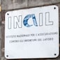Carrara, Italy - May 28, 2020 - Marble plaque at the entrance of an Inail building (Italian National Institute for Insurance against Accidents at Work)