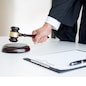 Male Judge lawyer In A Courtroom Striking The Gavel on sounding block.