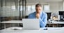 Busy serious middle aged professional business man financial investor, 50 year old senior businessman executive wearing suit using laptop computer working on investment project sitting at office desk.