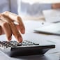 accountant working on desk using calculator for calculate finance report in office