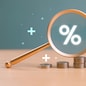 Interest rate rise, dividend money investment concept. Business provision of financial service. Gold magnifying glass finding on house loan interest rate percentage icon, mortgage rate blue background