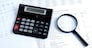 calculator, magnifier on financial reports. Business concept