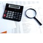 calculator, magnifier on financial reports. Business concept